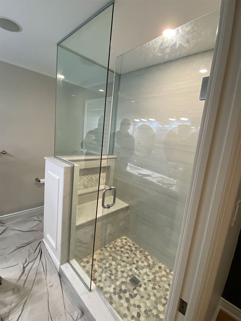 enclosed shower with glass wall and glass doors