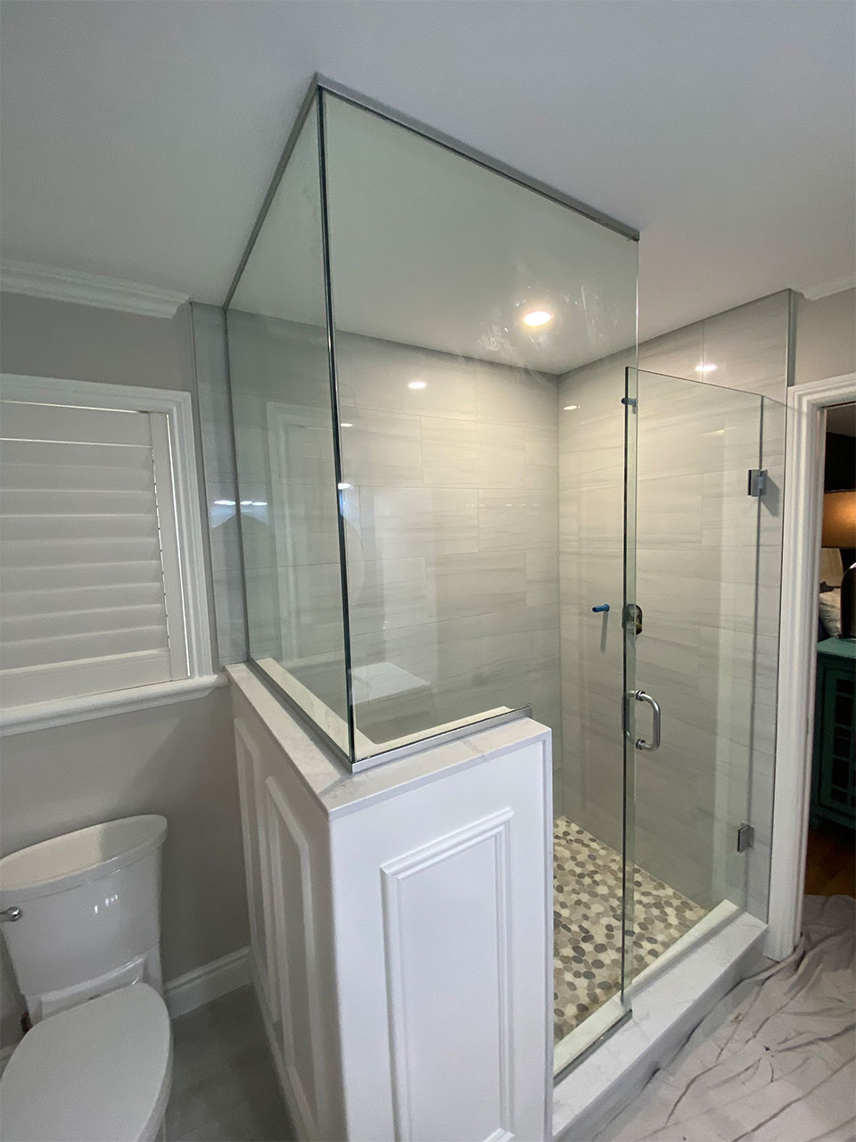 enclosed shower with glass wall and glass doors
